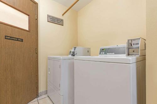 a laundry room with a washer and dryer next to a door at Days Inn by Wyndham Auburn in Auburn