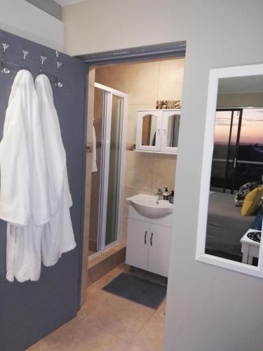 a bathroom with a sink and a white towel at Aguia-Vista Couples Haven, Views, Pool, Beach Walk in Jeffreys Bay