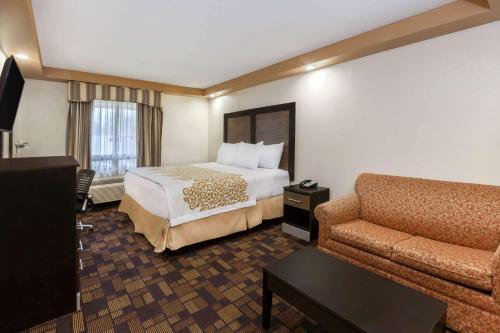 a hotel room with a bed and a couch at Days Inn by Wyndham Iselin / Woodbridge in Iselin