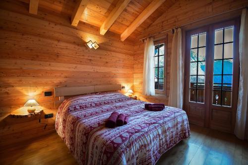 a bedroom with a bed in a log cabin at B&B Chalet Il Picchio in Varzo