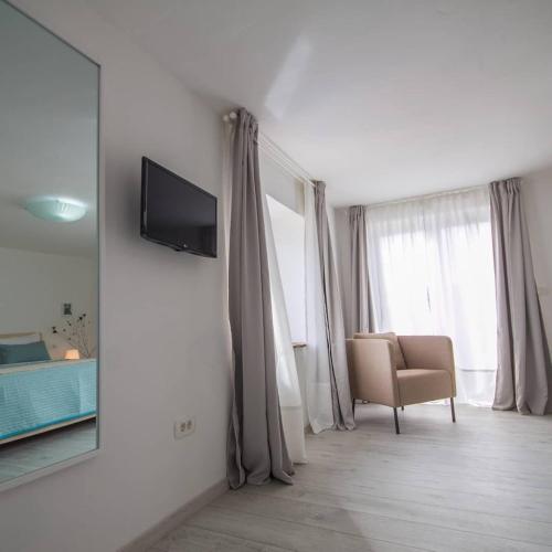 a living room with a mirror and a chair at Villa Mamma Mia Oprtalj in Oprtalj