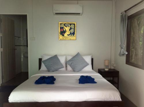 沙美島的住宿－日出海景度假村，一间卧室配有白色床和蓝色枕头