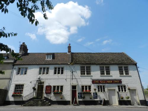 an old white building on the corner of a street at The Old Ham Tree in Holt