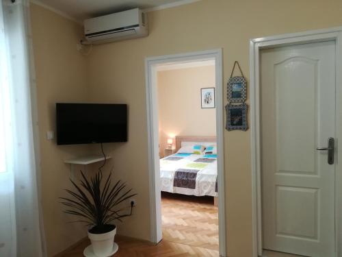 a bedroom with a bed and a flat screen tv at Apartment Nikolic Kotor in Kotor