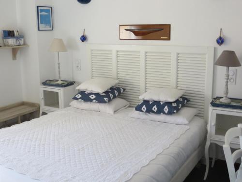 a bedroom with a white bed with two pillows at Hôtel Les Embruns Sables d'Olonne in Les Sables-dʼOlonne