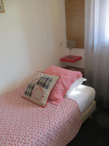 a bedroom with a bed with two pillows on it at Hôtel Les Embruns Sables d'Olonne in Les Sables-dʼOlonne