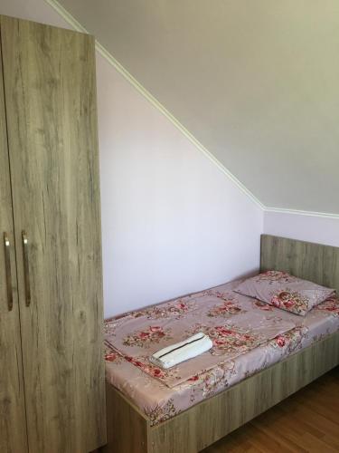 a bed in a room with a wooden cabinet at Homestay in Batumi Дом в Чакви in Chakvi