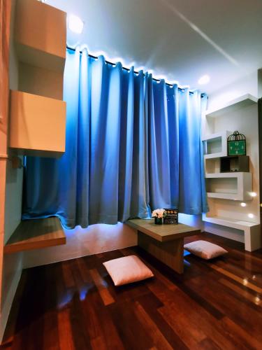 a living room with blue curtains and a table at MiCasa 2 Homestay in Sibu