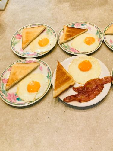 een groep eieren en toast op borden met spek bij Les 3 Tilleuls in Roye