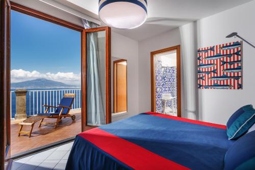 a bedroom with a bed and a balcony with a view at Hotel Torre Barbara in Vico Equense
