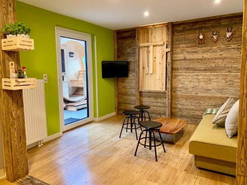 ein Wohnzimmer mit grünen Wänden, einem Sofa und Stühlen in der Unterkunft Boutique Appartments AlteGreißlerei in St. Wolfgang