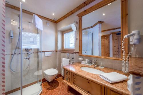 a bathroom with a sink and a shower and a toilet at Sport- und Genusshotel Silvretta in Ischgl