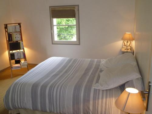a bedroom with a large bed with a window at Villa familiale aux portes du Médoc et de Bordeaux in Blanquefort