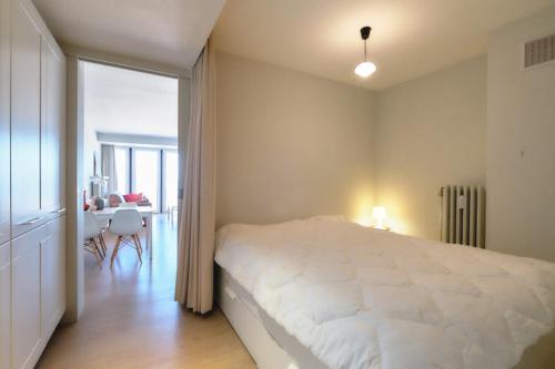 a bedroom with a large white bed and a table at Sealover in Ostend