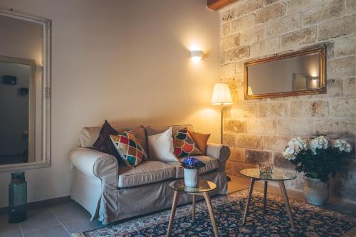 a living room with a couch and a brick wall at Antica Villa Colonica in Sorso