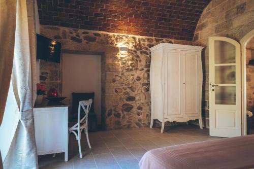 a bedroom with a white cabinet in a brick wall at Antica Villa Colonica in Sorso
