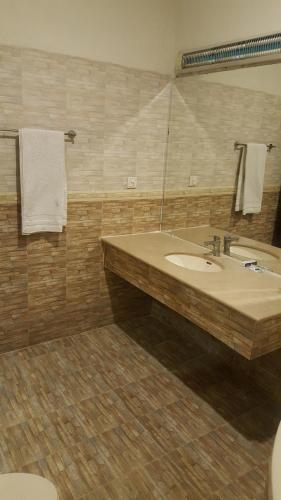 ein Bad mit einem Waschbecken und einem Spiegel in der Unterkunft Mulberry Residence Family Rooms in Islamabad