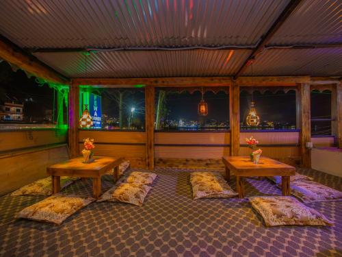 a room with three tables and a view of the city at Hotel Fewa Corner & Restro in Pokhara