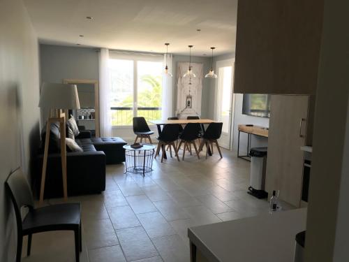 a living room with a couch and a table and chairs at Appartement plein centre Saint Florent face au port in Saint-Florent