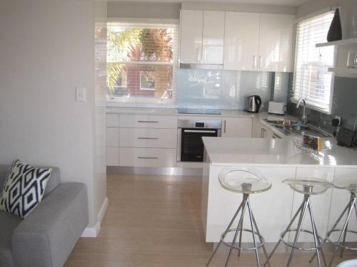 a kitchen with white cabinets and a counter top at Cronulla Beach Break in Cronulla