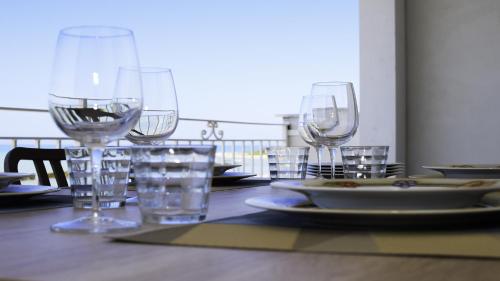 a table with wine glasses and plates of food on it at Terrazza sul Mediterraneo in Seccagrande