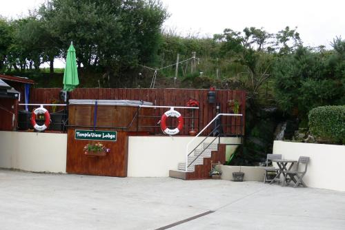 a fence with a staircase and a green umbrella at Rustic Log Cabin in Greencastle