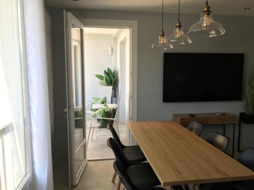 ein Esszimmer mit einem Holztisch und Stühlen in der Unterkunft Appartement plein centre Saint Florent face au port in Saint-Florent