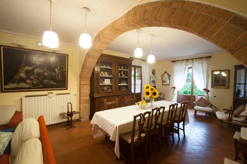 a dining room with a table and chairs in a room at Podere Sionne in Chiusi