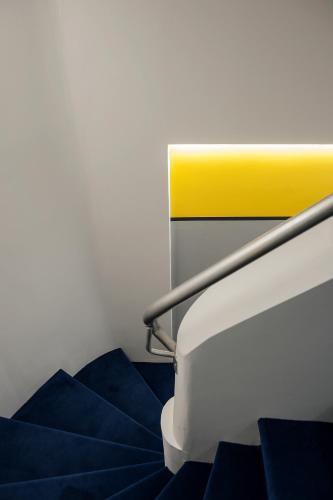a staircase with blue steps and a yellow railing at Hotel Hito in Vitoria-Gasteiz