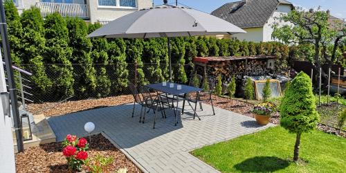 a patio with a table and an umbrella at Apartments Gerda in Vřesina