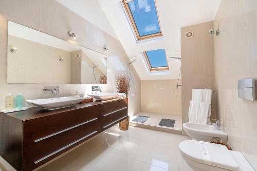 フンシャルにあるDeluxe 4 bedroom Apartmentのバスルーム(シンク、トイレ付)、天窓が備わります。