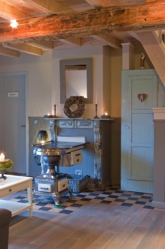 a kitchen with a counter and a table in a room at Bij de Zöster in Kinrooi