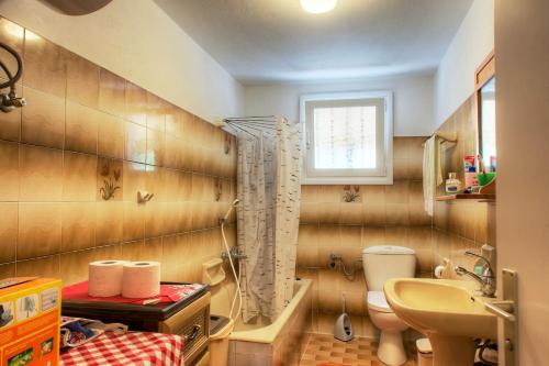 a bathroom with a sink and a toilet and a window at KANAKADES VILLAGE HOUSE in Corfu