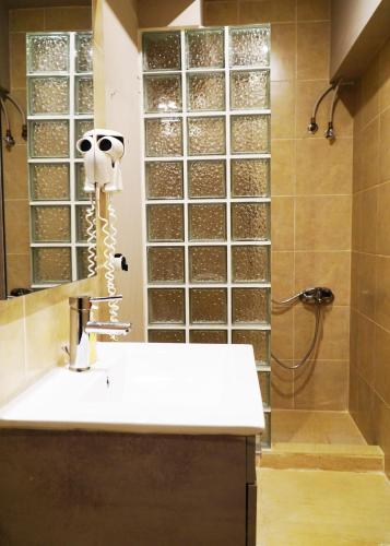 a bathroom with a sink and a shower at me gusta suite by the sea in Anavissos