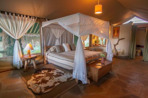 a bedroom with a bed with a canopy at Kibo Safari Camp in Amboseli