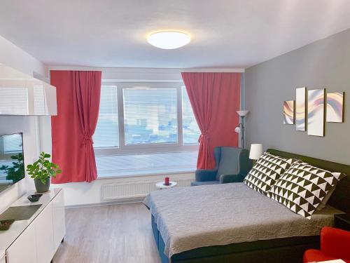 Un dormitorio con una cama y una ventana con cortinas rojas. en RS Apartments, en Olomouc
