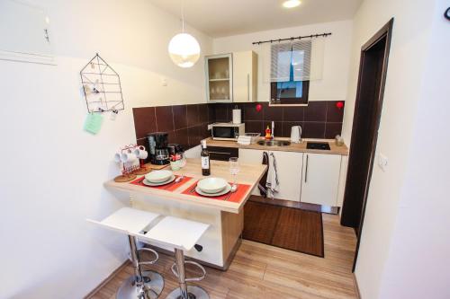 cocina con mesa y 2 sillas blancas en Apartment Lynn, en Poreč
