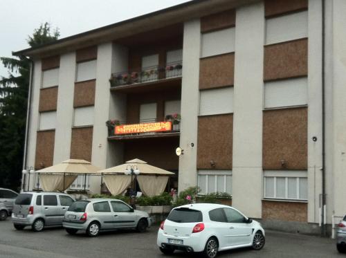 a building with three cars parked in front of it at Albergo Cristallo in Cittiglio