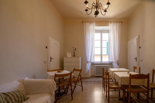 una sala de estar con mesas, sillas y una ventana en Le Violette, en Lucca