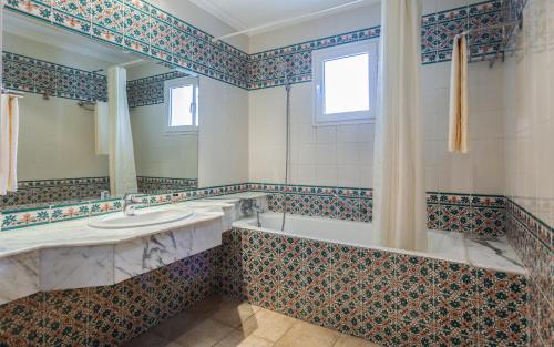La salle de bains est pourvue d'une baignoire, d'un lavabo et d'un miroir. dans l'établissement Le Corail Appart'Hotel Yasmine Hammamet, à Hammamet