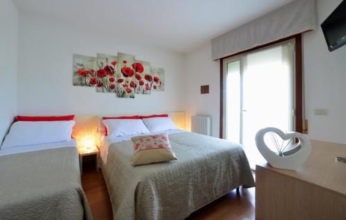 1 Schlafzimmer mit 2 Betten und einem Fenster in der Unterkunft Condominio Al Cigno in Lignano Sabbiadoro