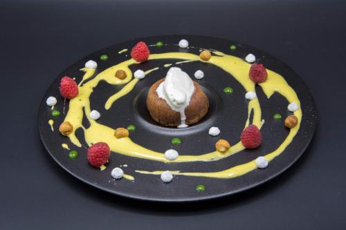 a plate with a chocolate cake with whipped cream and raspberries at Isola Verde Resort in Castiglione del Lago