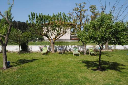 a group of chairs sitting in the grass under a tree at Villa Spyros in Sivota
