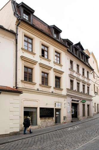 eine Person, die vor einem großen Gebäude läuft in der Unterkunft Hostel Eleven in Brünn