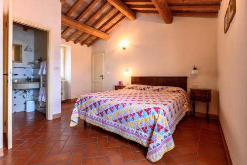 a bedroom with a bed with a colorful comforter at La locanda del Povero Diavolo in Torriana