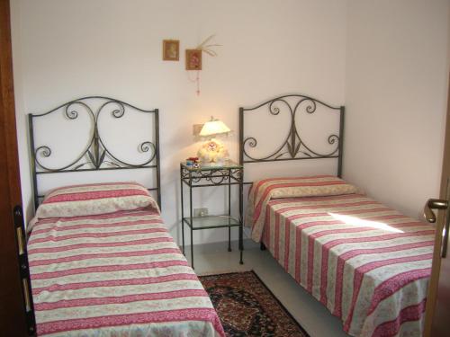 芡歐的住宿－Casa dei Fiori，一间卧室配有两张床和一张带台灯的桌子