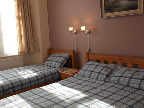 een kamer met 2 bedden en een raam bij Ashfield Guest House in Torquay
