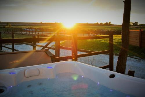 a hot tub with the sunset in the background at Clover Lodge in Chesterfield