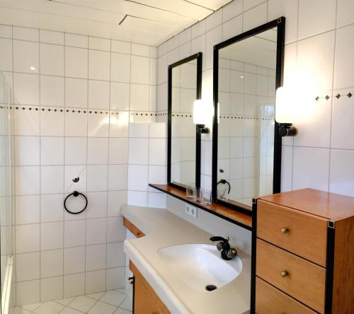 baño con lavabo y 2 espejos en Ferienhaus Alpenland, en Flachau