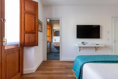 a bedroom with a bed and a tv on a wall at Marcus Suite in Cagliari